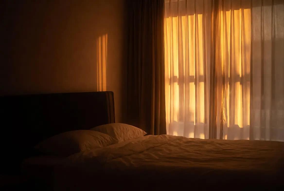 Chambre baignée d'une lumière douce et apaisée symbolisant des nuits sans cauchemars après un désenvoûtement durable