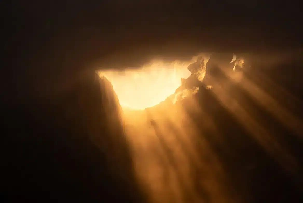 Lumière dorée traversant l'obscurité, symbole de la clarté retrouvée après avoir su si on est envoûté
