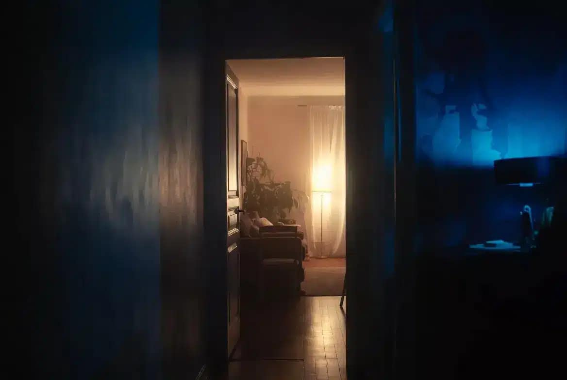 Intérieur d'appartement français au crépuscule avec atmosphère lourde caractéristique d'une maison ensorcelée